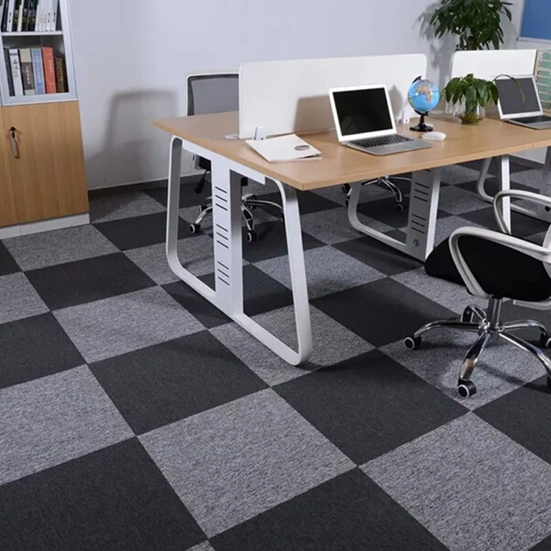 Black and light grey checkered carpet tiles in office workspace