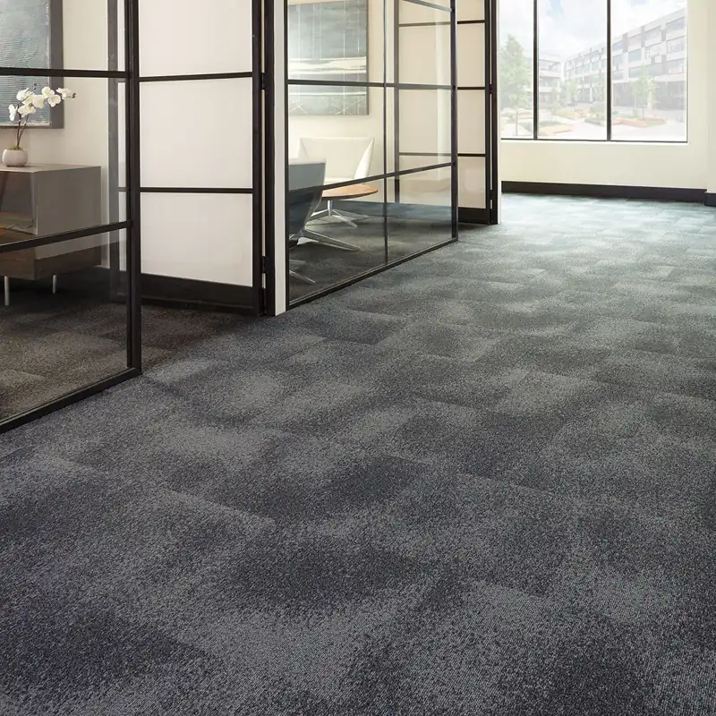 Dark grey carpet tiles in an office corridor.