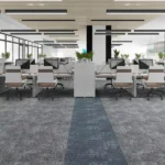 Gray carpet tiles with a central blue walkway in an open office workspace