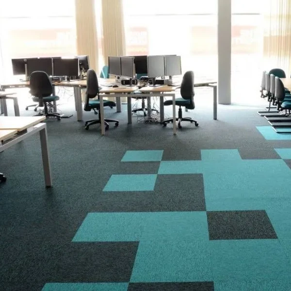 Turquoise and dark gray patterned commercial carpet tiles in an office space.