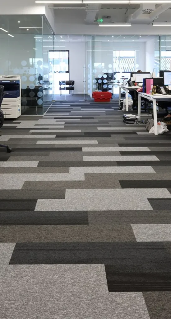 striped geometric pattern office carpet tiles installed in a modern workspace corridor.